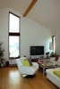 Reference dřevostavby na klíč - obývací prostor s přiznaným stropem a atypickým oknem